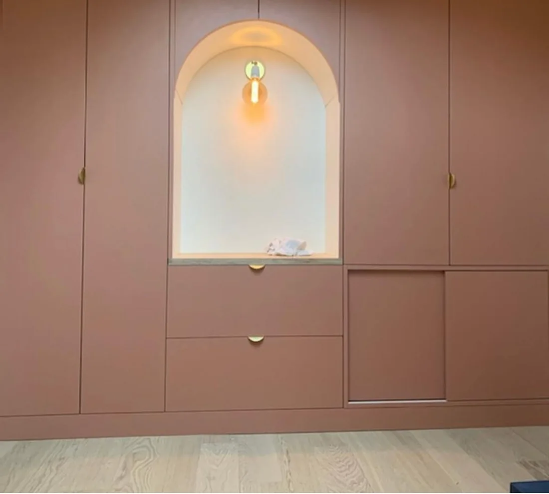Dressing sur mesure rose poudré avec niche en arche éclairée et poignées laiton