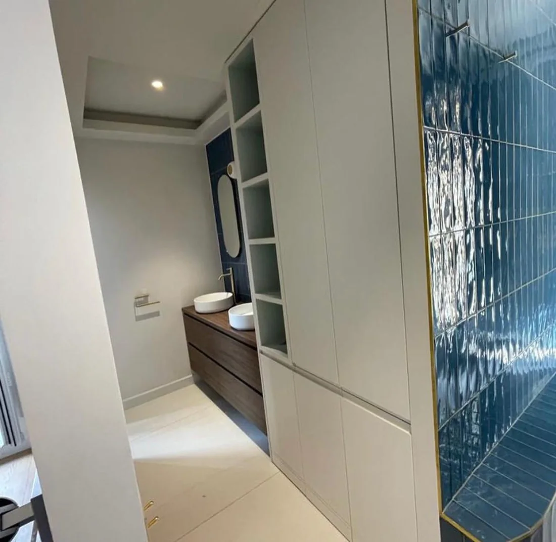 Salle de bain avec agencement gris clair toute hauteur et cloison en zellige bleu brillant